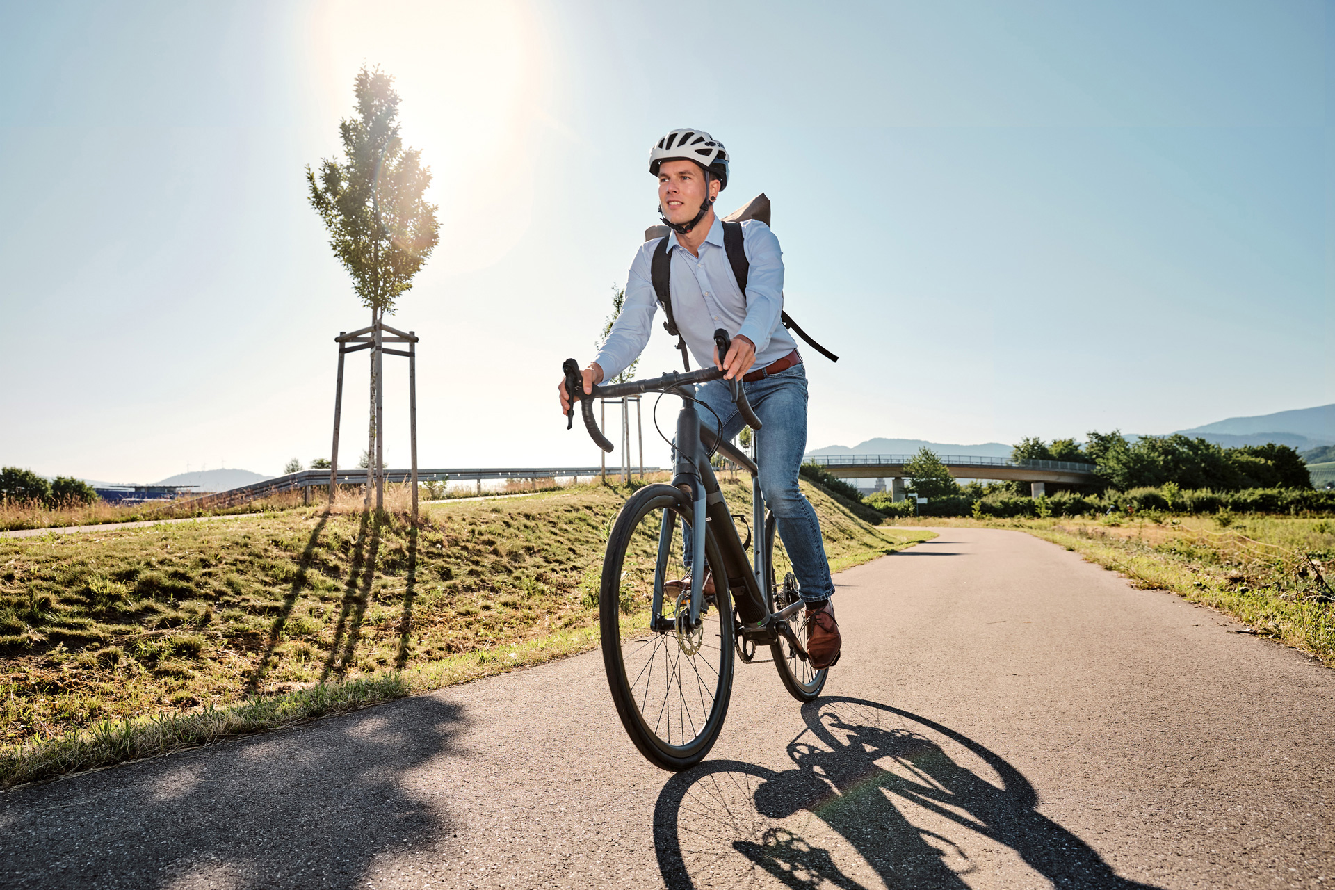 Mann fährt mit dem Fahrrad durch einen Park